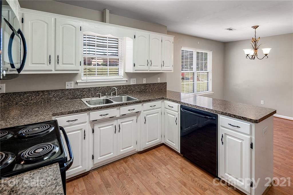 8577 Unity Church Road Denver, NC 28037 - Photo 10 of 33 a kitchen with granite countertop white cabinets and white appliances