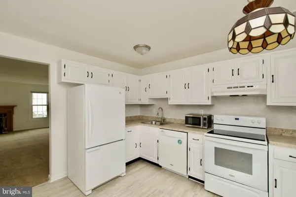 a kitchen with stainless steel appliances white cabinets and a refrigerator