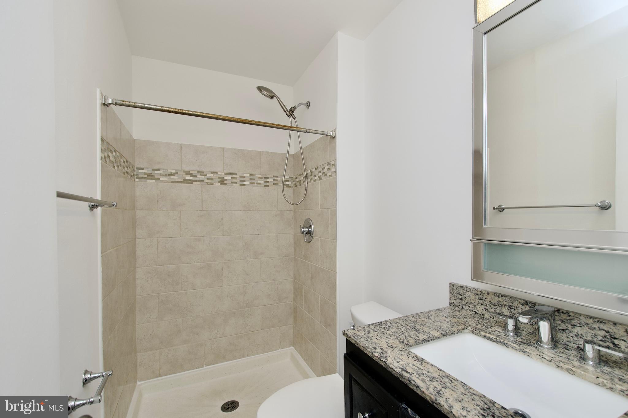 1448 Orleans Court Crofton, MD 21114 - Photo 27 of 32 a bathroom with a granite countertop shower sink vanity and toilet