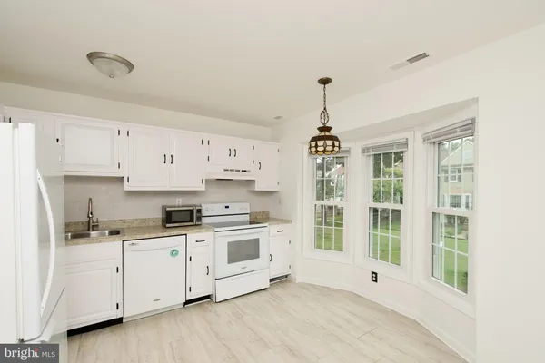 a kitchen with a stove a sink and a window