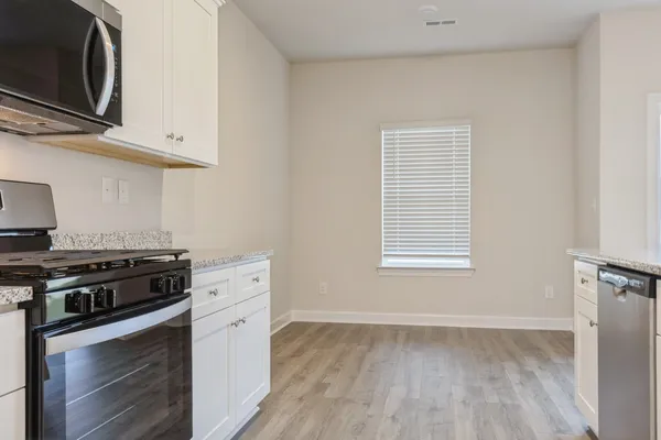 a kitchen with stainless steel appliances a stove microwave and sink