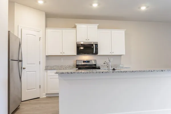 a kitchen with stainless steel appliances granite countertop a stove a sink and a refrigerator