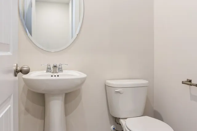 a bathroom with a toilet sink and mirror