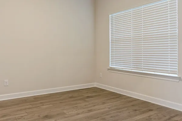 a view of a small space with wooden floor and a window