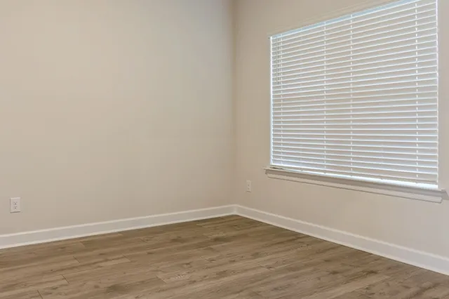a view of a small space with wooden floor and a window
