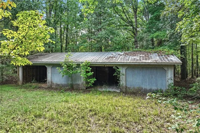 a view of a house with a small yard and a large tree