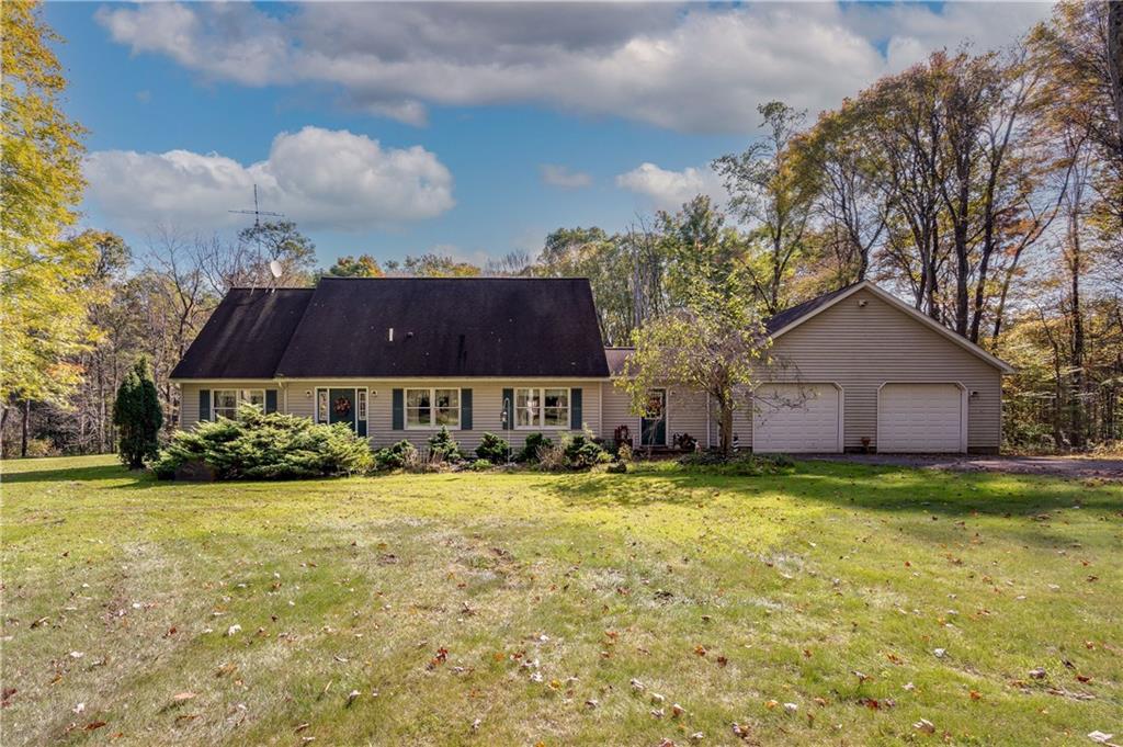 a view of a house with garden yard and a tree