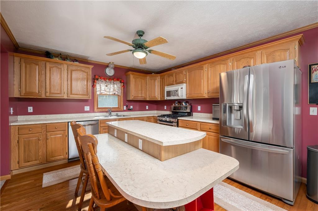 360 Sopher Road Grove City, PA 16127 - Photo 6 of 25 a kitchen with stainless steel appliances granite countertop a refrigerator a sink a stove a dining table and chairs with wooden floor