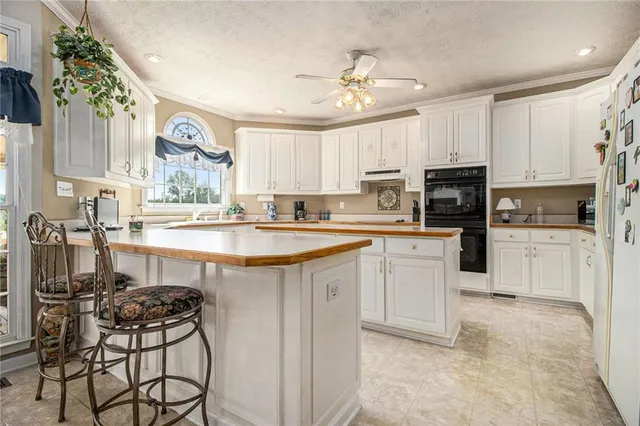 a kitchen with kitchen island granite countertop a sink counter top space appliances and cabinets