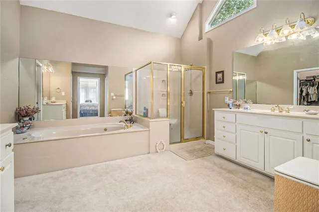 a spacious bathroom with a double vanity sink a mirror and a shower