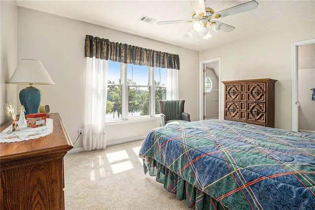 a spacious bedroom with a bed and a chandelier