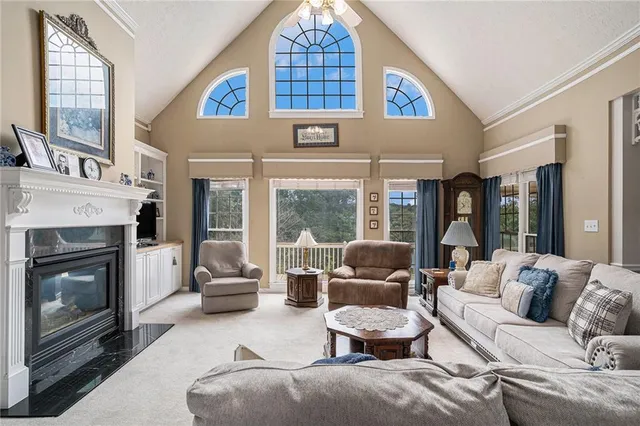 a living room with furniture large window and fireplace
