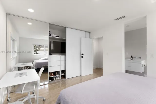 a spacious bedroom with a bed and a view of kitchen