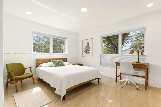 a bedroom with a bed a table and a window