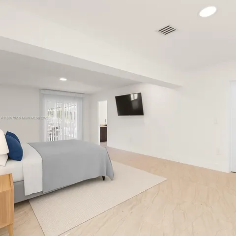 a living room with a bed furniture and a flat screen tv