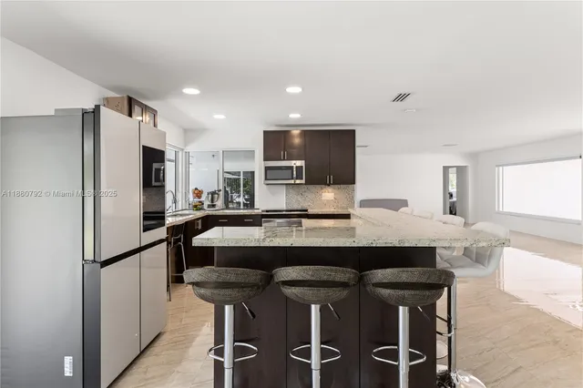 a kitchen with stainless steel appliances a refrigerator and a microwave