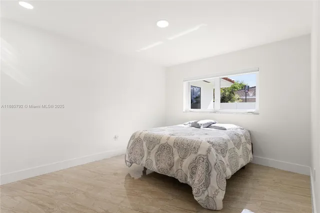 a bed sitting in a bedroom next to a window