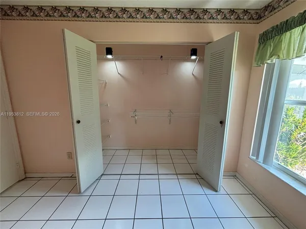 a kitchen with stainless steel appliances kitchen island granite countertop a stove and white cabinets