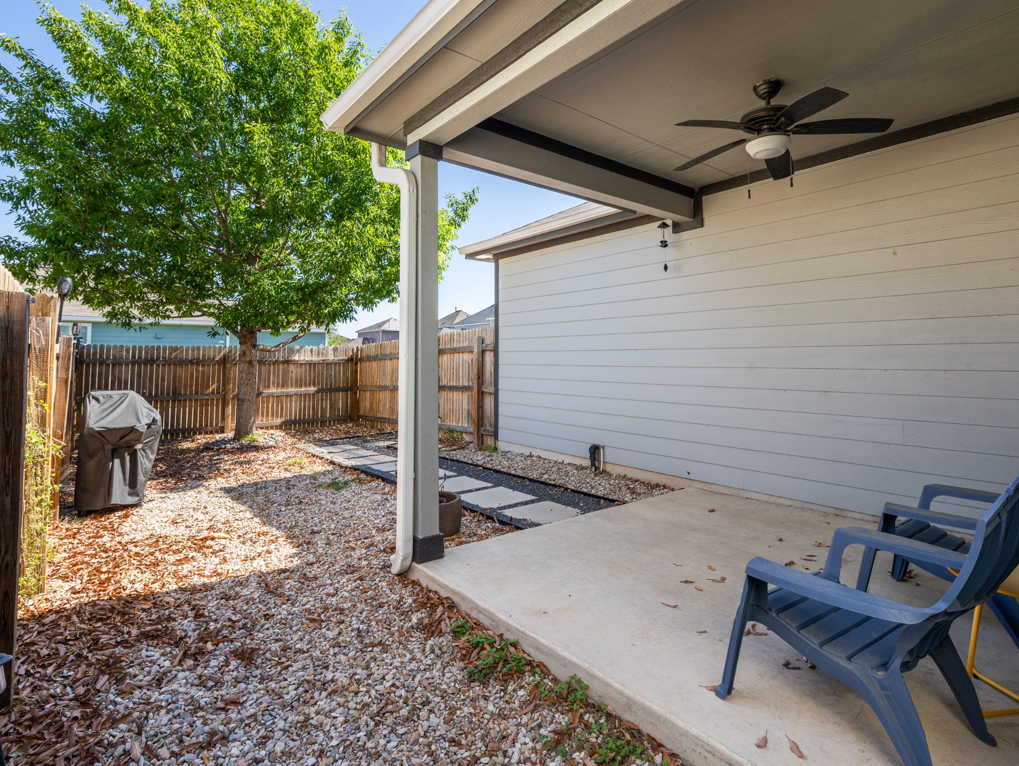 1919 Rinker Ranch Drive Austin, TX 78725 - Photo 21 of 30 Fenced backyard with ceiling fan, a patio, and grilling area