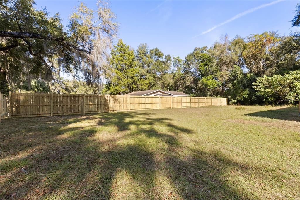 1251 Northwest 23rd Avenue Ocala, FL 34475 - Photo 29 of 34 a view of yard with swimming pool and trees in the background