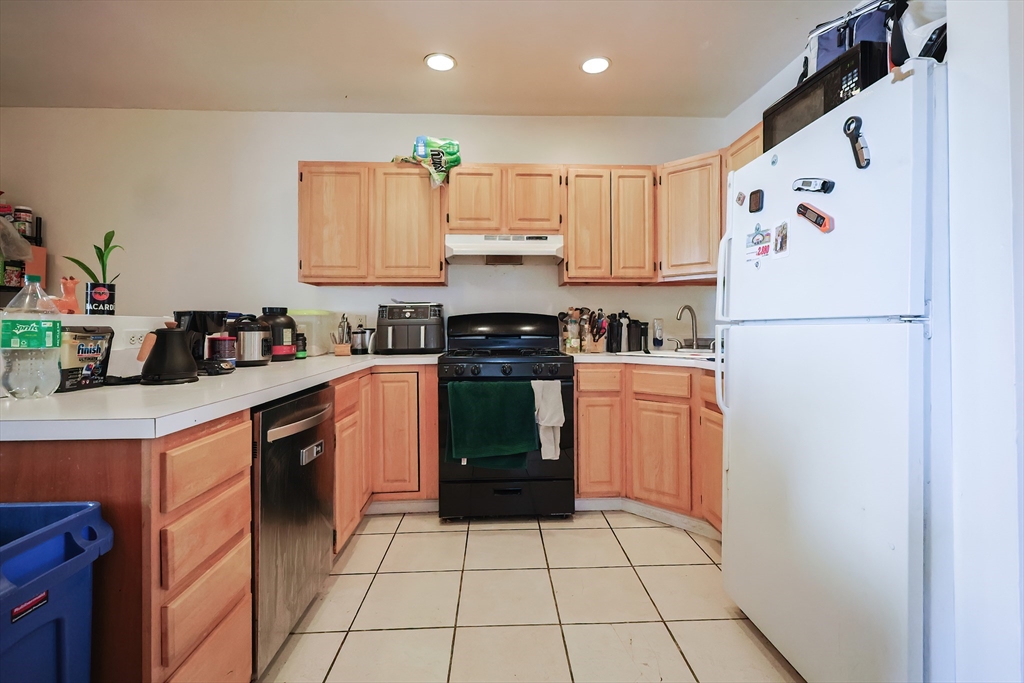 35 Adamson Street Boston, MA 02134 - Photo 24 of 41 a kitchen with a refrigerator a stove top oven a sink and cabinets