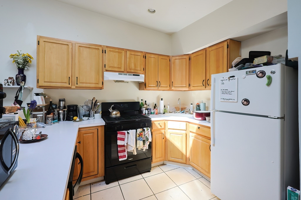 35 Adamson Street Boston, MA 02134 - Photo 35 of 41 a kitchen with stainless steel appliances granite countertop a refrigerator and a stove top oven