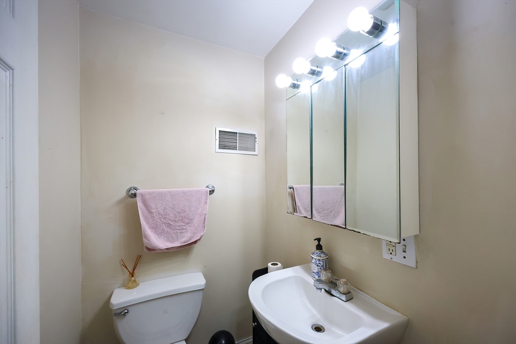 35 Adamson Street Boston, MA 02134 - Photo 8 of 41 a bathroom with a toilet sink vanity and mirror
