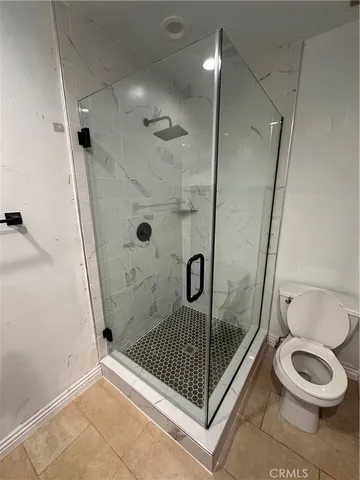 a bathroom with a shower a toilet and a sink
