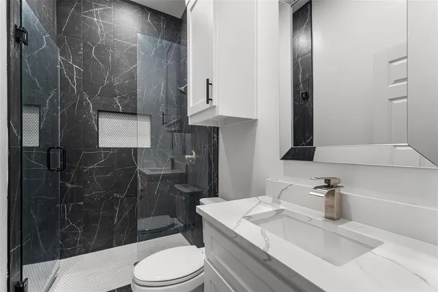 a bathroom with a sink toilet and shower