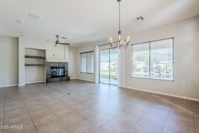 a view of a kitchen and an empty room with wooden floor