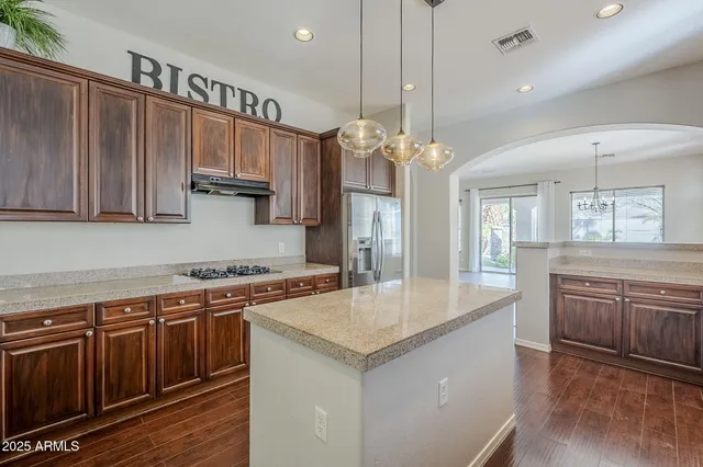 a kitchen with kitchen island a counter space a sink appliances and cabinets