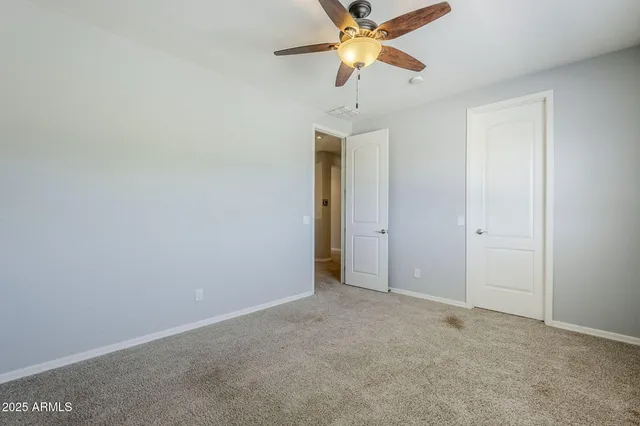an empty room with closet and windows