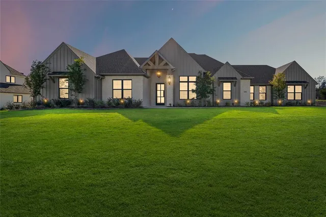 a view of a big house with a big yard and large trees