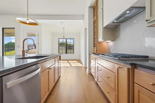 a large kitchen with granite countertop a stove and a sink