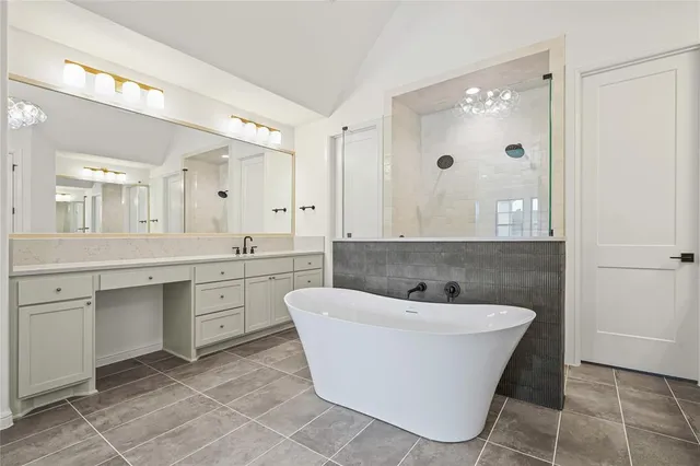 a bathroom with a bathtub sink shower and mirror