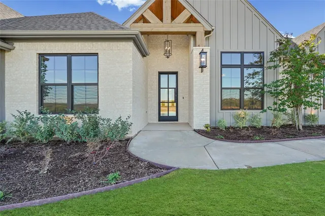 a front view of a house with a yard and potted plants