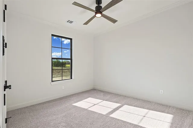 an empty room with windows and ceiling fan