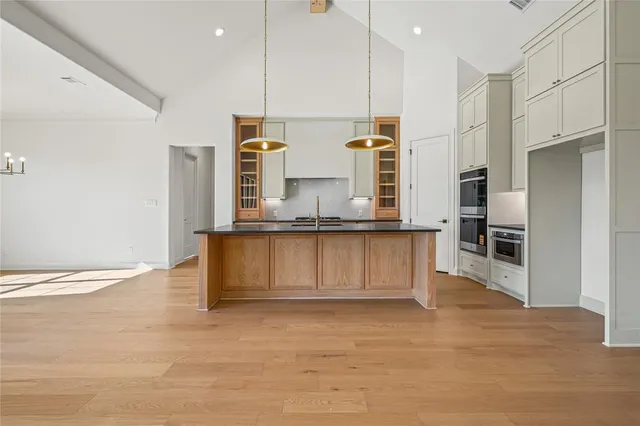 a kitchen with stainless steel appliances granite countertop a stove a sink and a refrigerator