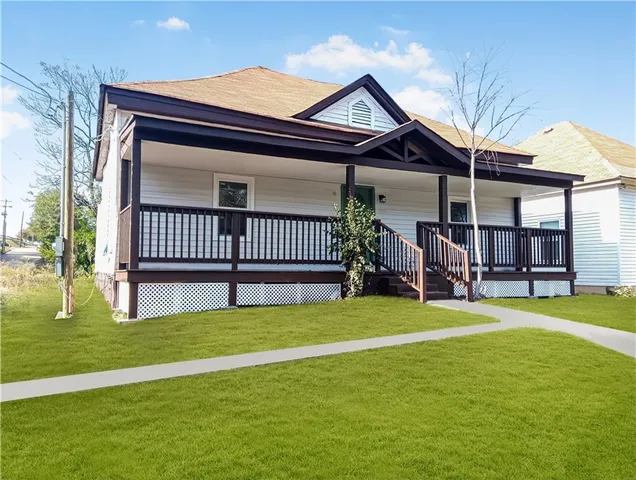 a view of a house with a porch and a yard