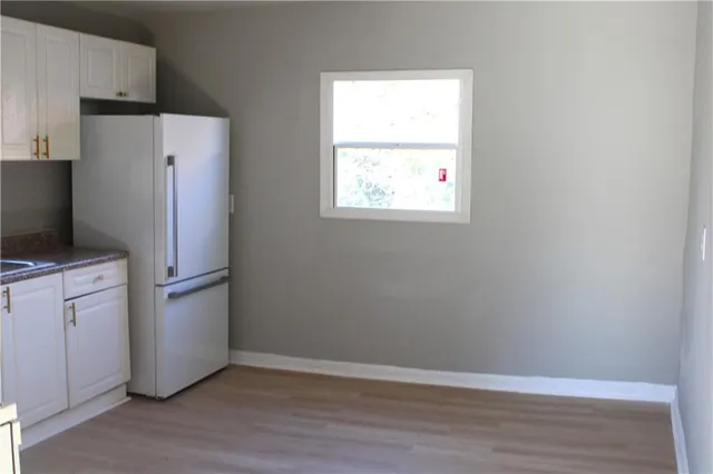 a view of a refrigerator in kitchen and wooden floor