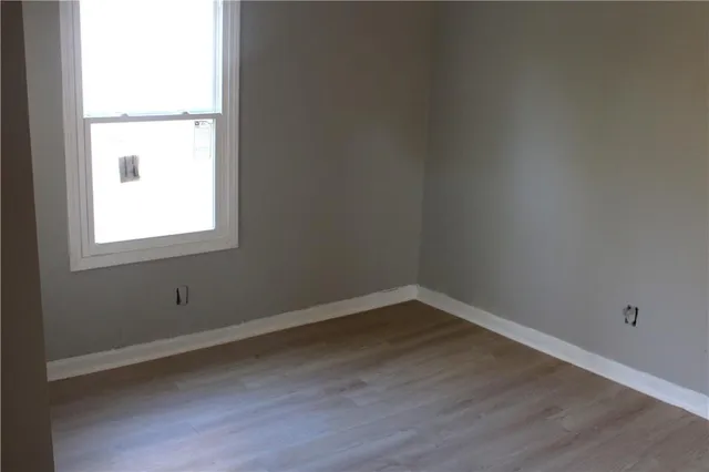 a view of a small space with wooden floor and a window