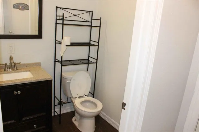 a bathroom with a toilet sink vanity and mirror