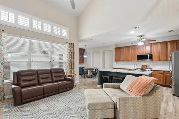 a kitchen with stainless steel appliances granite countertop a kitchen island hardwood floor sink stove dining table and chairs