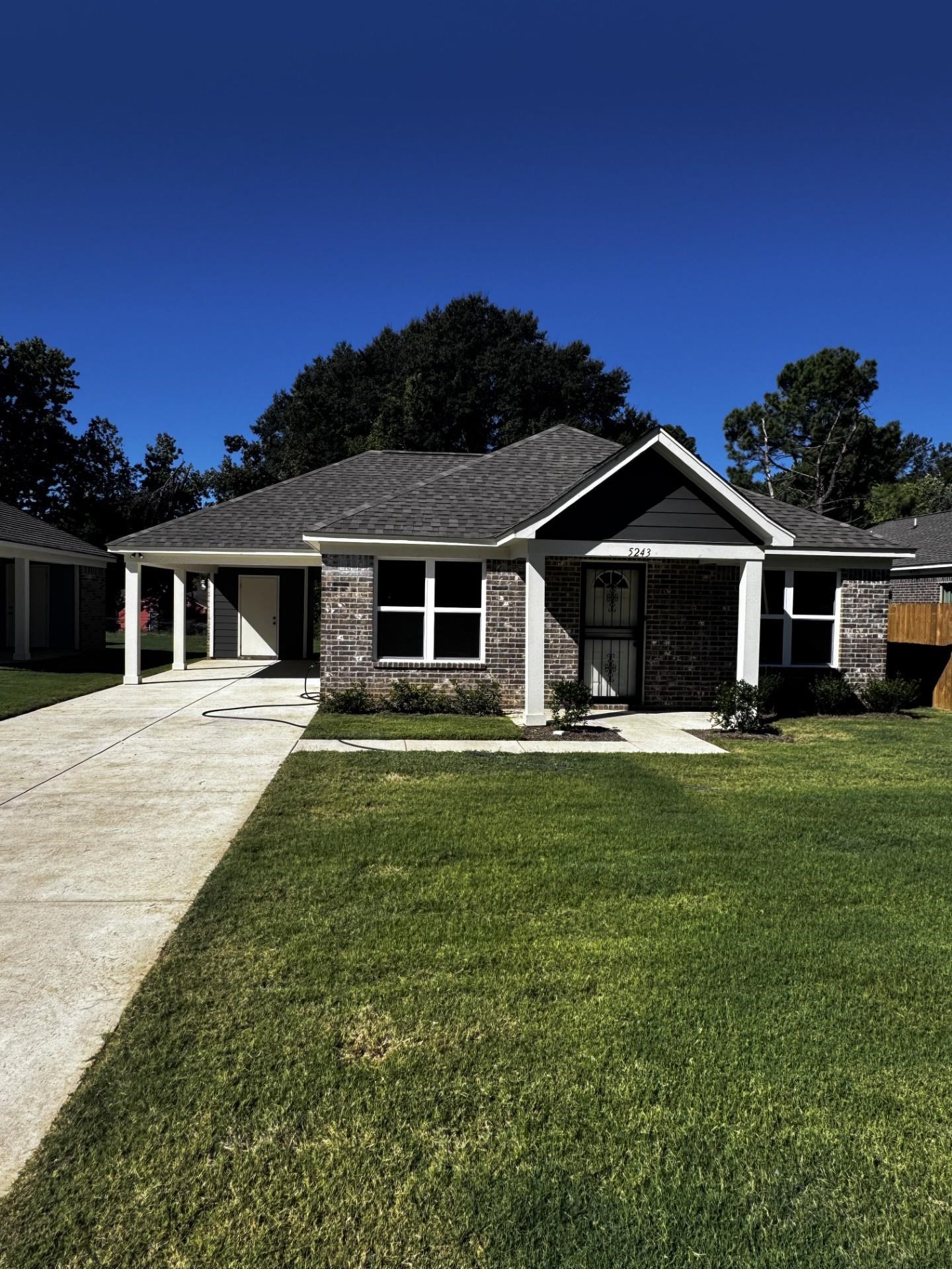 5243 Zodiac Road Memphis, TN 38118 - Photo 1 of 10 Ranch-style house featuring driveway, a front yard, an attached carport, and a shingled roof