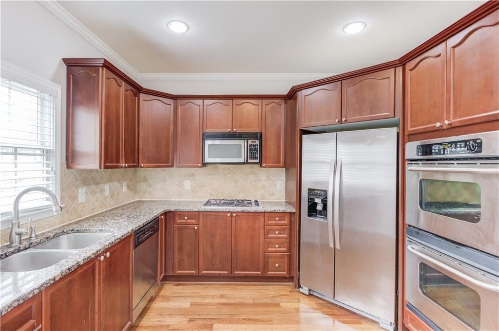 11007 Lorin Way Duluth, GA 30097 - Photo 13 of 30 a kitchen with stainless steel appliances granite countertop a refrigerator a sink and a stove