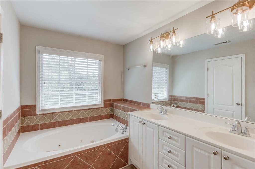 11007 Lorin Way Duluth, GA 30097 - Photo 20 of 30 a bathroom with a tub sink and mirror