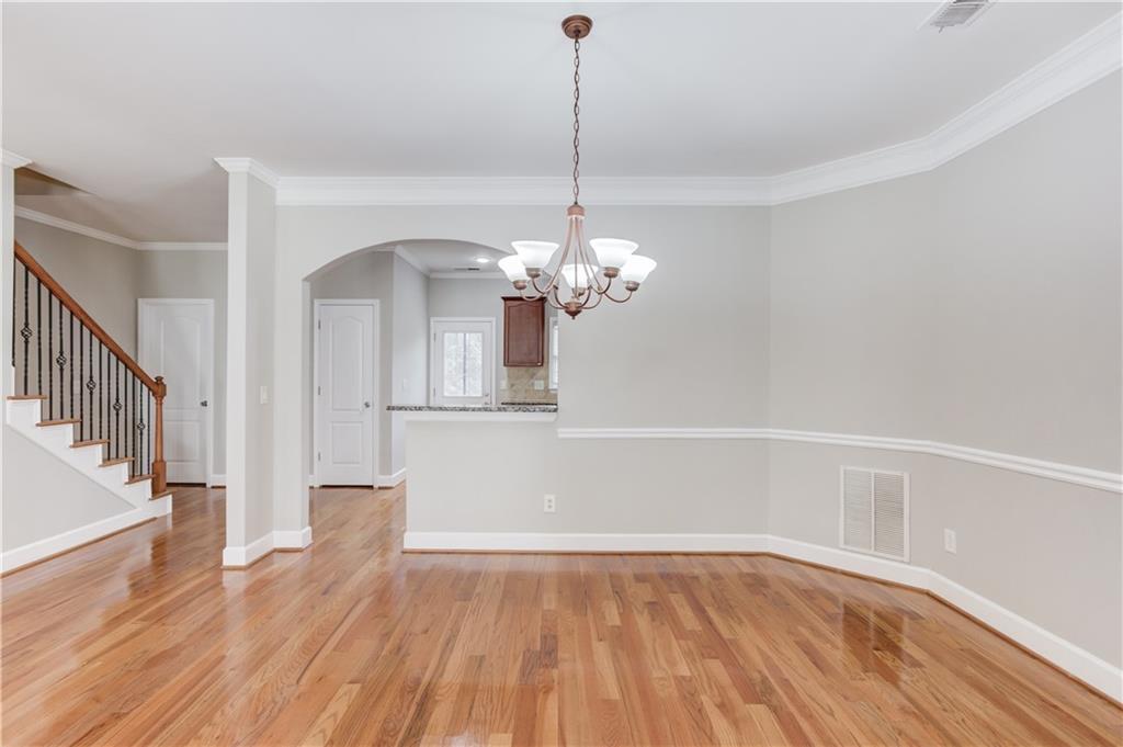 11007 Lorin Way Duluth, GA 30097 - Photo 10 of 30 a view of a room with wooden floor and chandelier