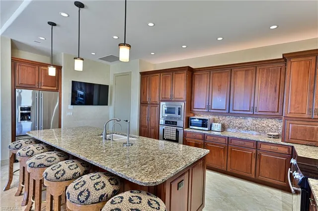 a kitchen with stainless steel appliances granite countertop a stove a sink and a refrigerator