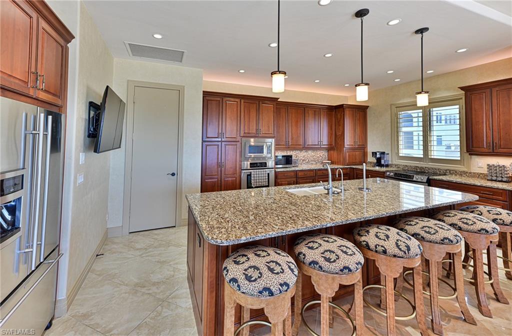 110 St Eustacius Lane Bonita Springs, FL 34134 - Photo 14 of 34 a kitchen with granite countertop a stove a sink and a refrigerator