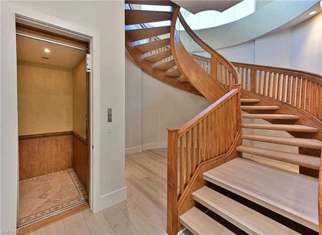 a view of staircase with white walls and railing